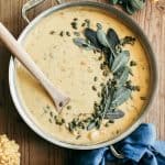 Pumpkin Beer & Sharp Cheddar Gnocchi Soup in a saute pan with a wooden spoon.