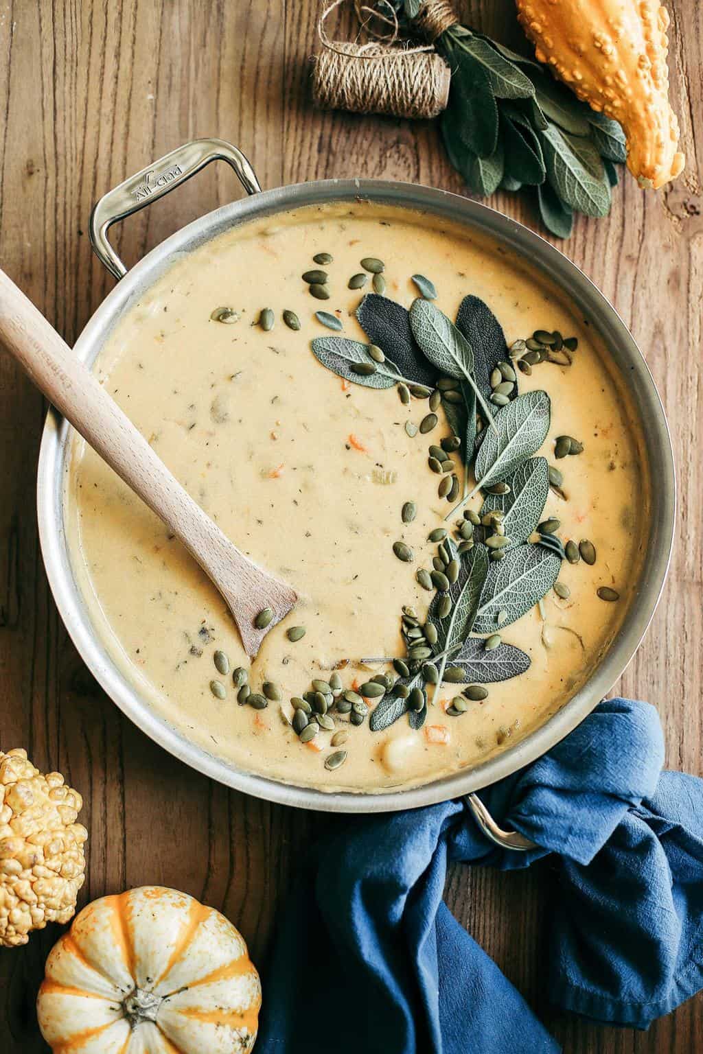 Pumpkin Beer & Sharp Cheddar Gnocchi Soup in a saute pan with a wooden spoon.