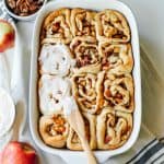 A casserole of Apple Pecan Cinnamon Rolls with icing