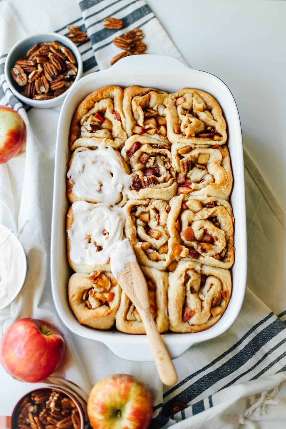 A casserole of Apple Pecan Cinnamon Rolls with icing