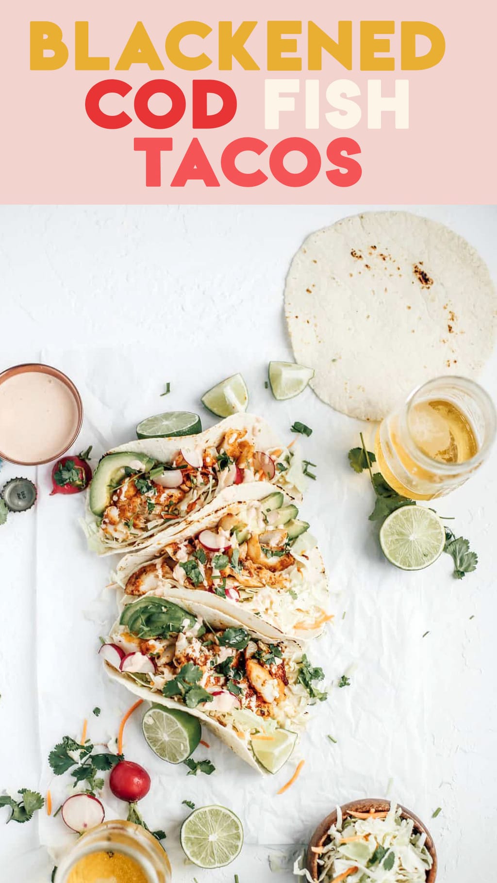 Three blackened cod tacos with a bowl of cabbage and two glasses of beer.