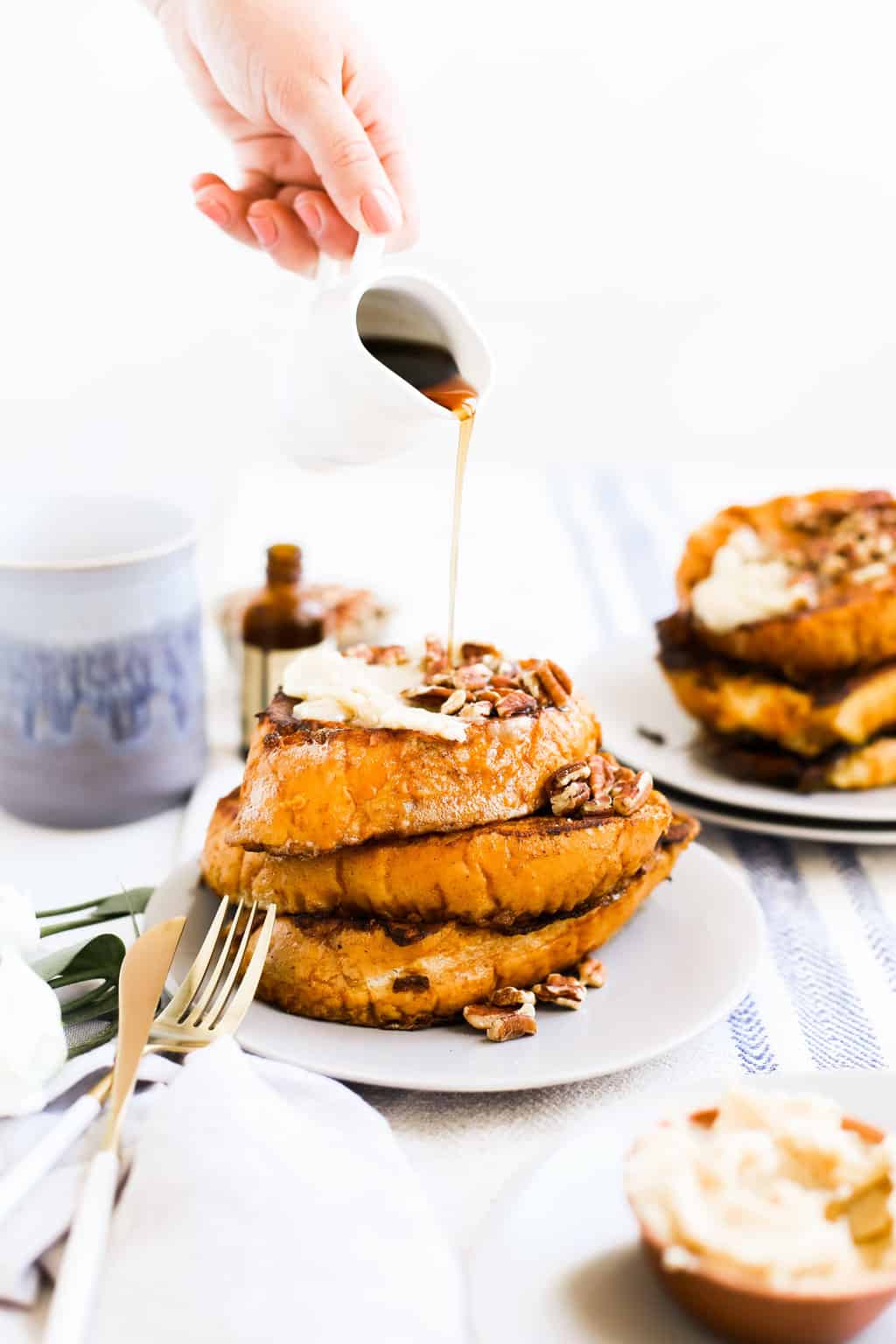 A stack of Pumpkin Spice French Toast on a plate with syrup being poured.