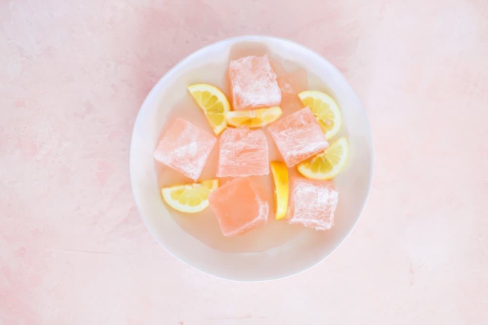 Frose Ice Cubes and Lemon Slices in a White Bowl