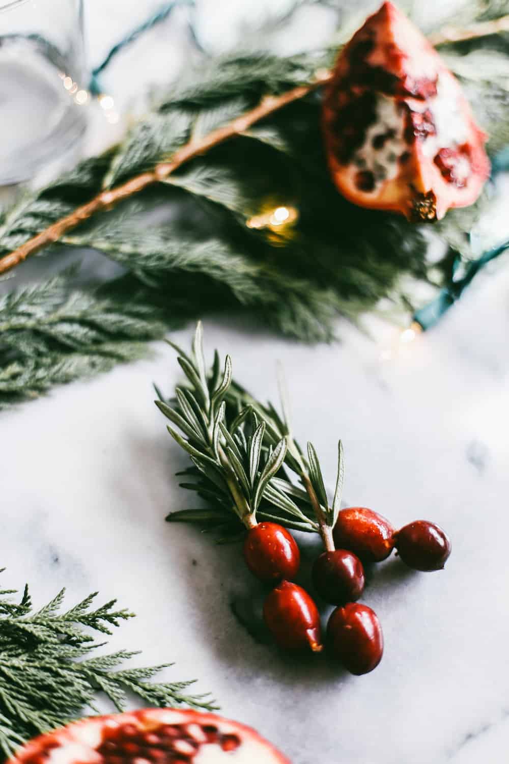 Three rosemary sprigs with cranberries. 