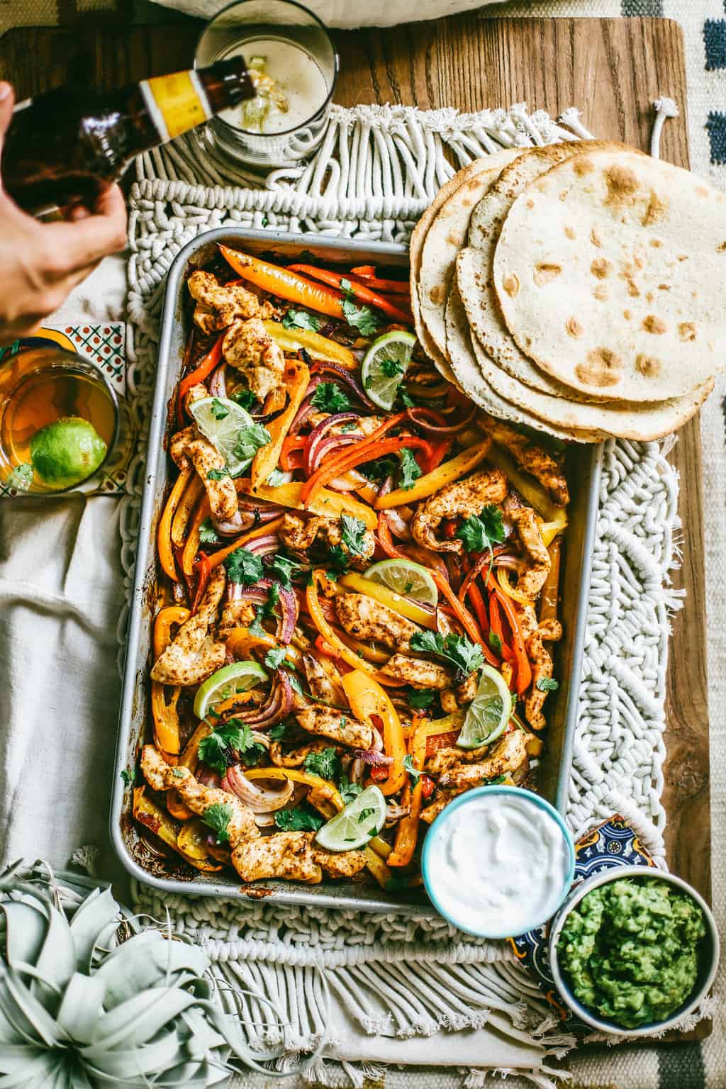 chili lime chicken and vegetables on a sheet pan with flour tortillas on the side