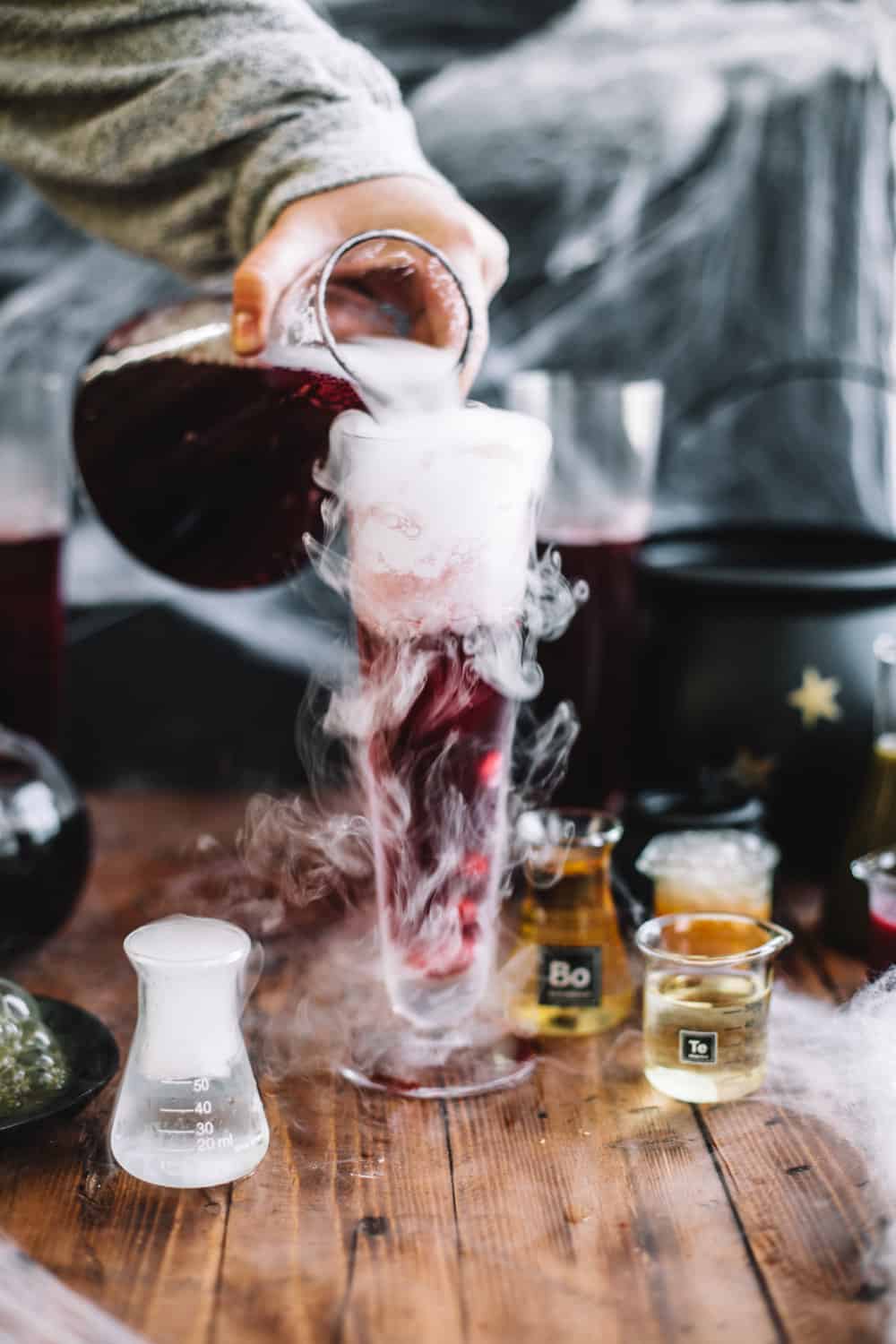 Tall glasses with dry ice, Pomegranate Polyjuice Potion being poured. 