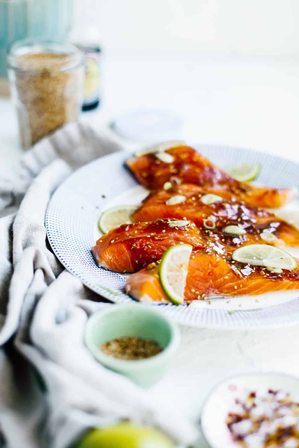 salmon fillets marinating in soy glaze on white plate