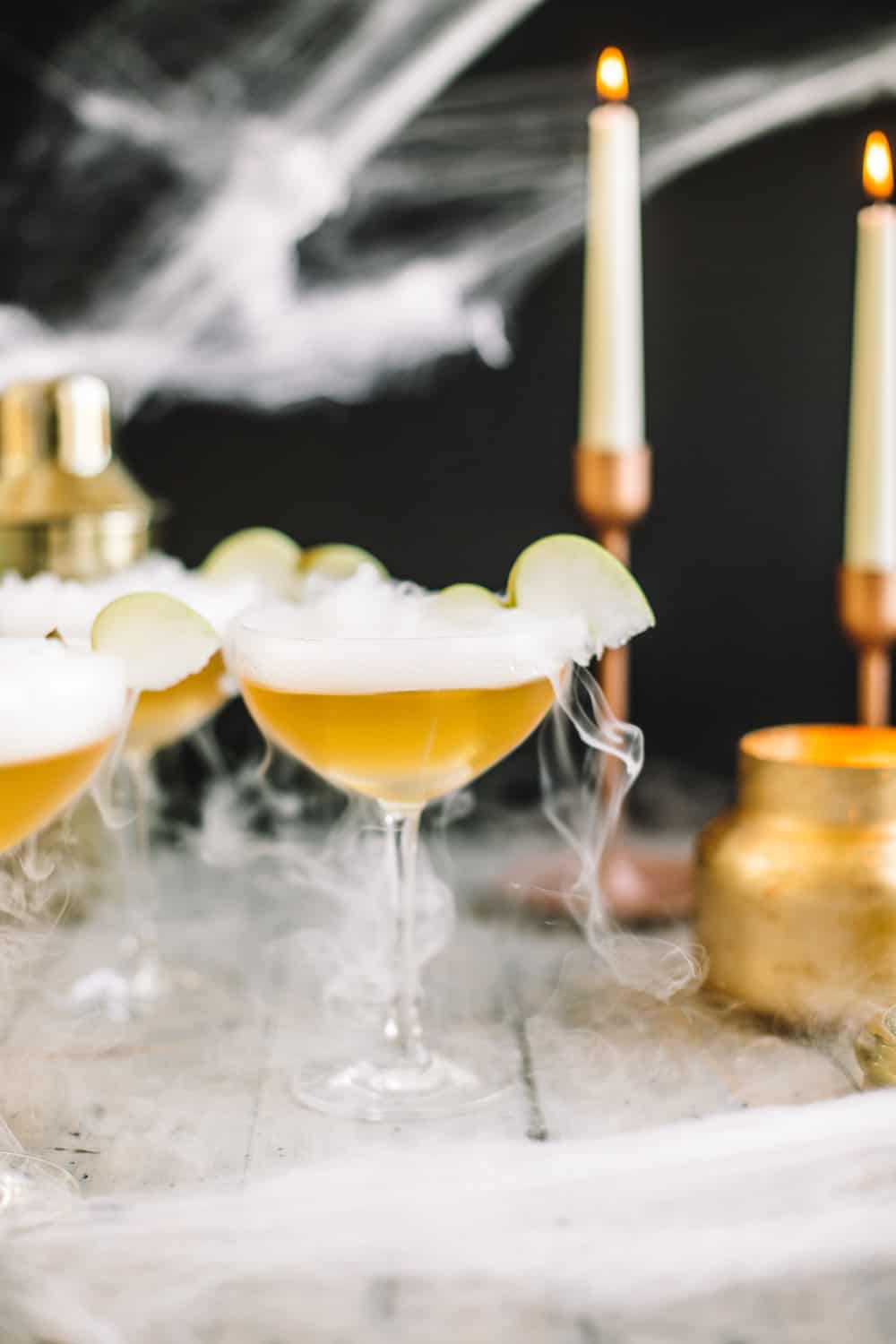 Elderflower wand martini garnished with dry ice and a sliced apple.