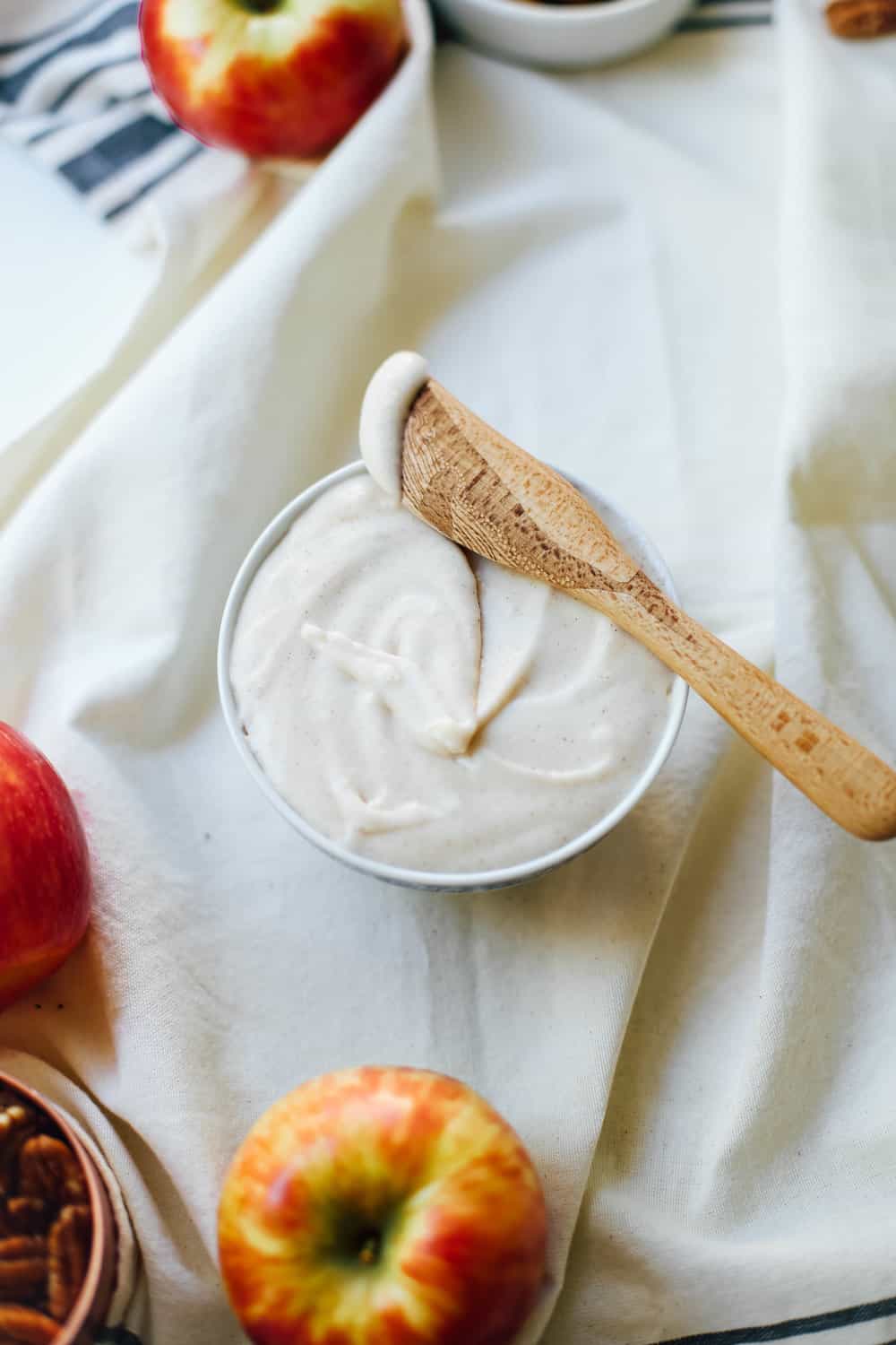 A bowl of icing with a wooden knife. 