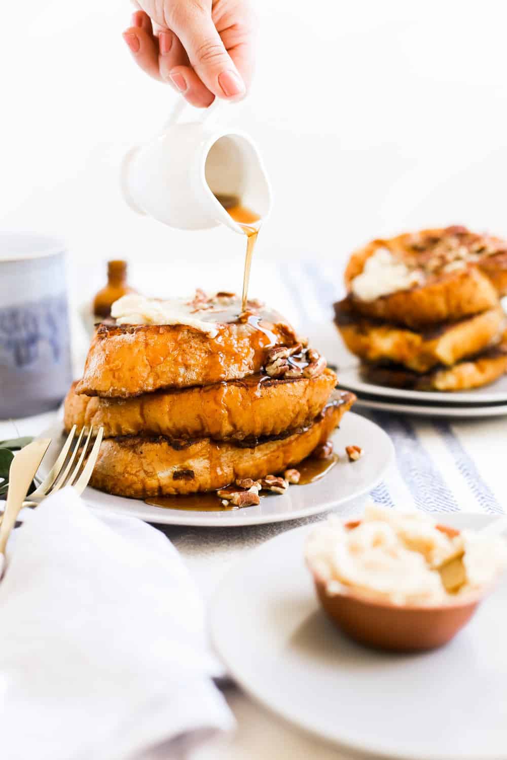 A stack of Pumpkin Spice French Toast on a plate with syrup being poured. 