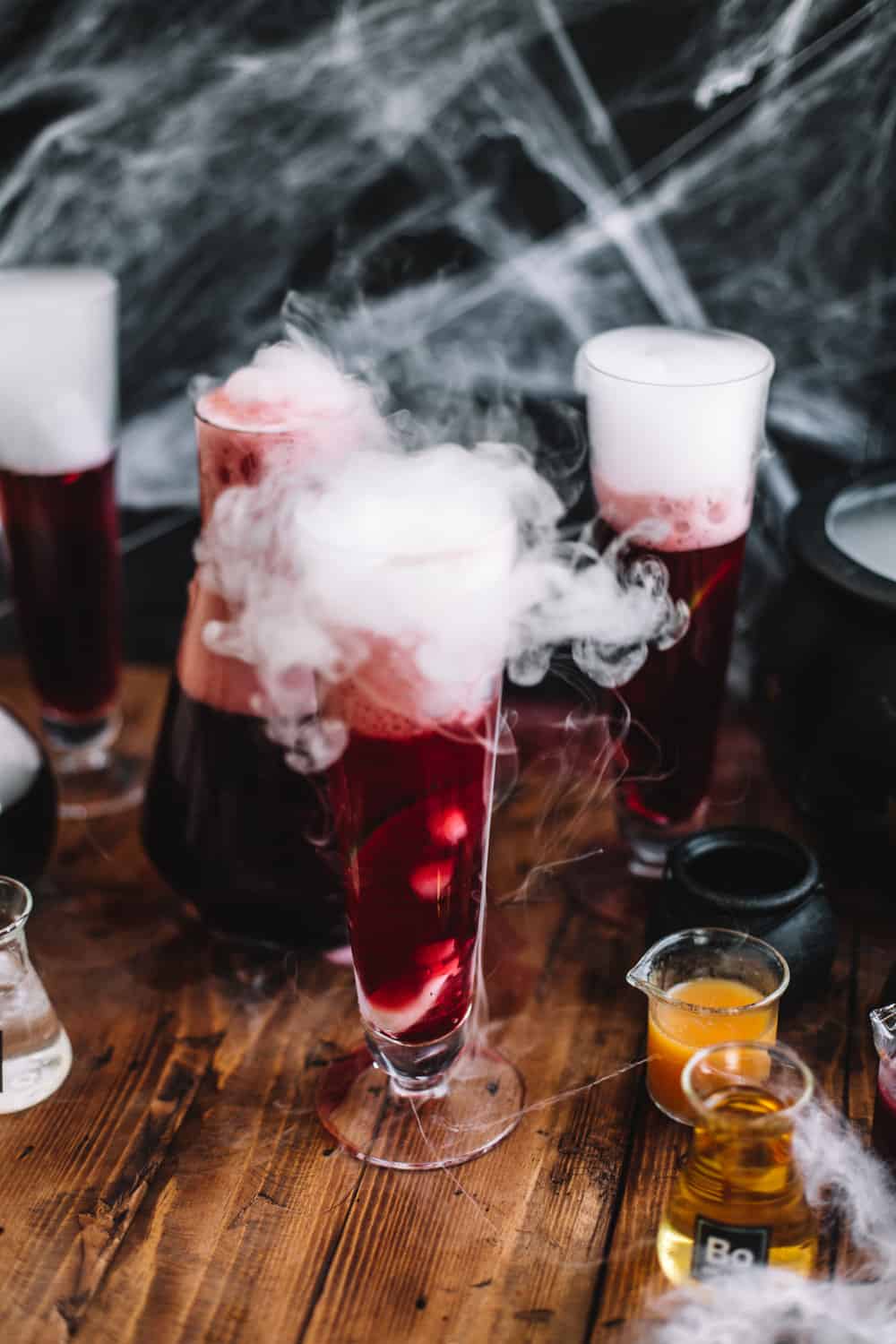 Tall glass of Pomegranate Polyjuice Potion with dry ice.