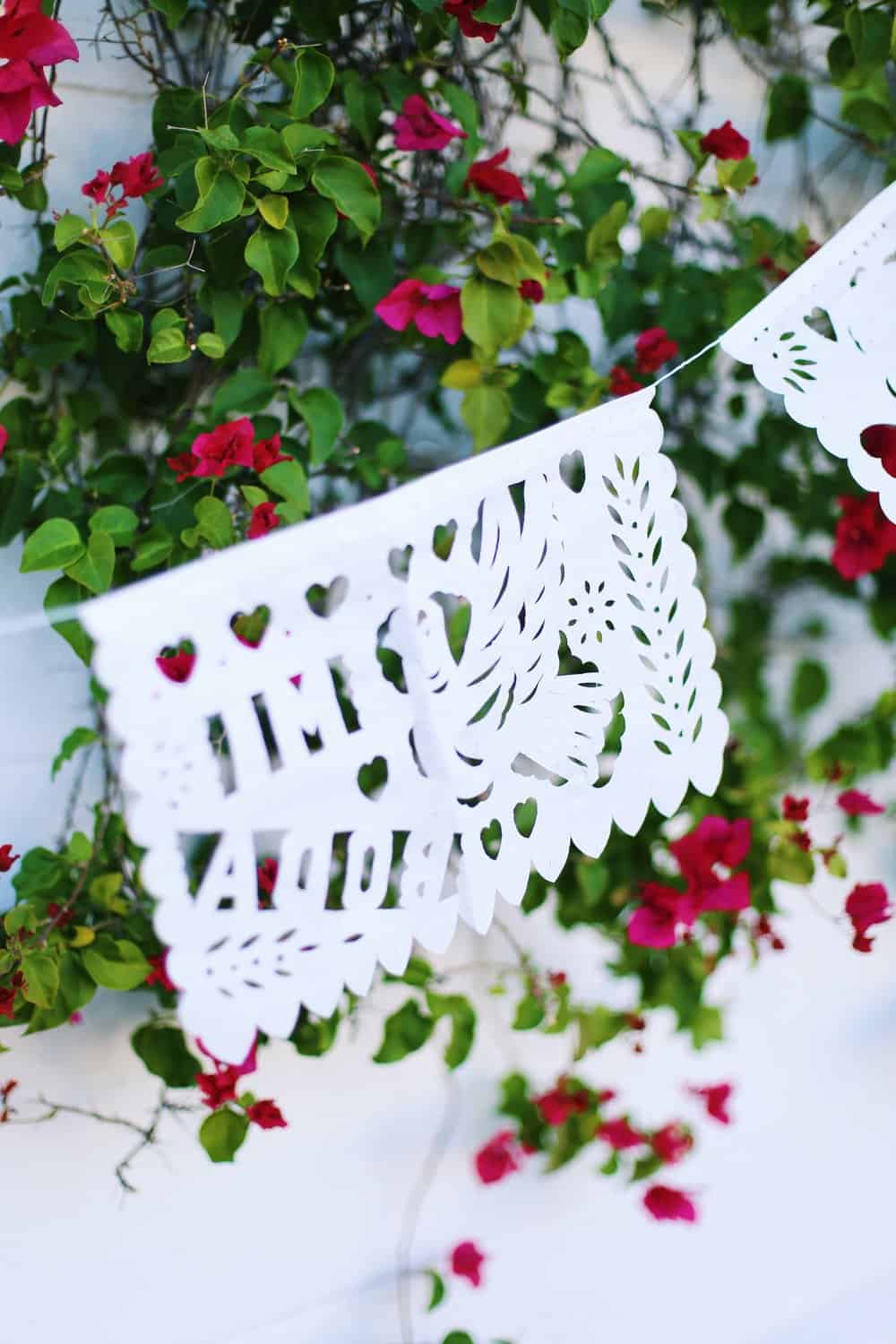 Festive Mexican banner decoration with flowers in the background