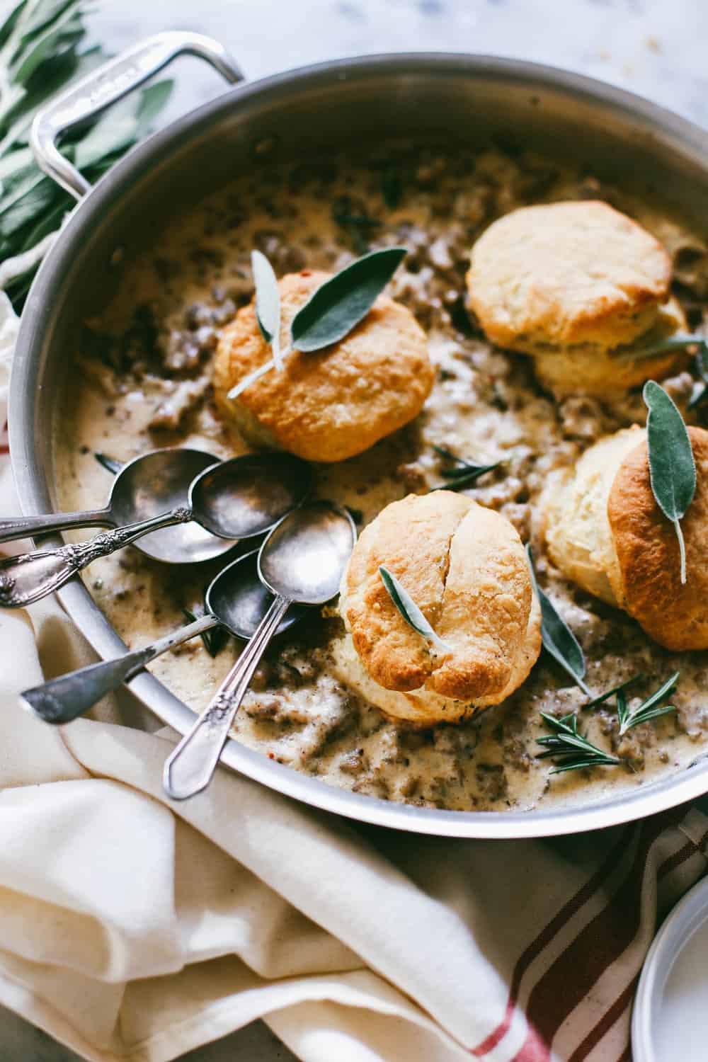 Bourbon Biscuits and Sage Sausage Gravy in a pan with spoons.