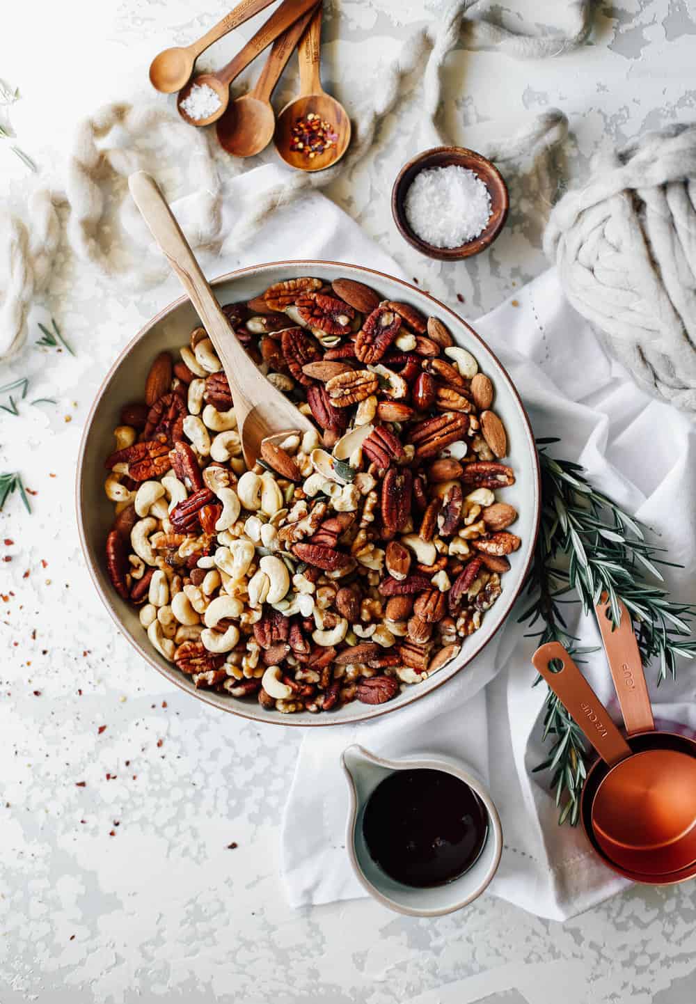 Large bowl of nuts with a wooden spoon. 