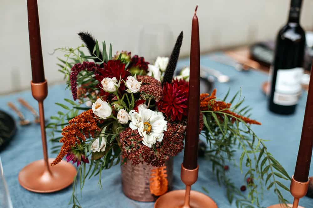 Moody and Dark floral arrangements with long taper candles. 