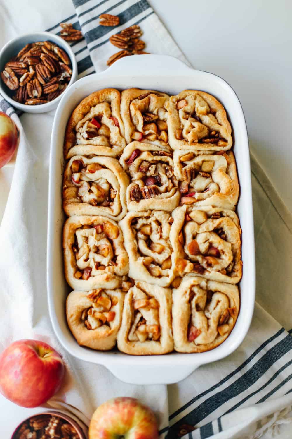 Baked apple pecan cinnamon rolls in a casserole dish.