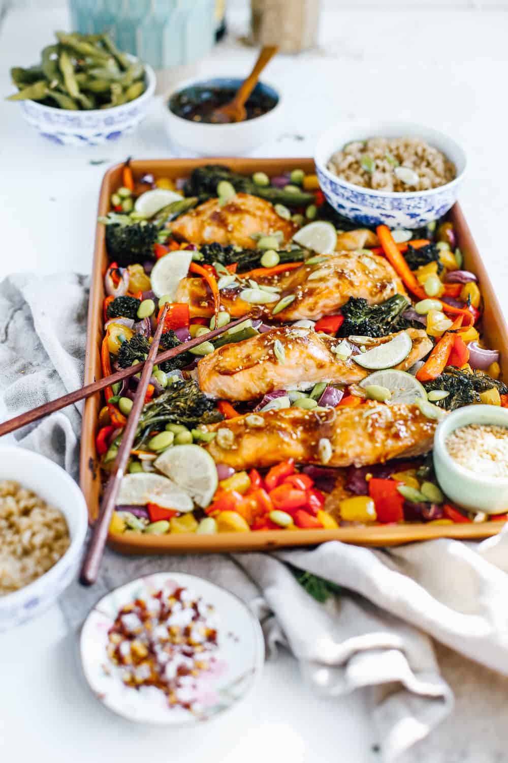 soy, garlic and ginger glazed salmon with broccolini, carrots, peppers and onions on sheet pan with chopsticks