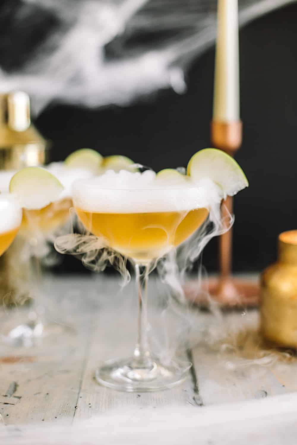 Elderflower Wand Martini garnished with dry ice and a sliced apple. 