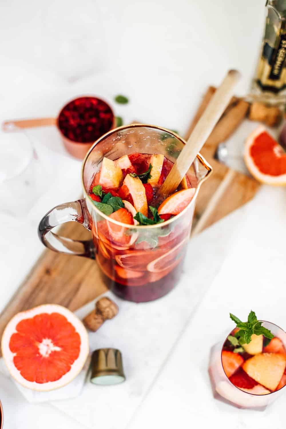 A pitcher of strawberry champagne sangria with fresh grapefruit and strawberry slices.