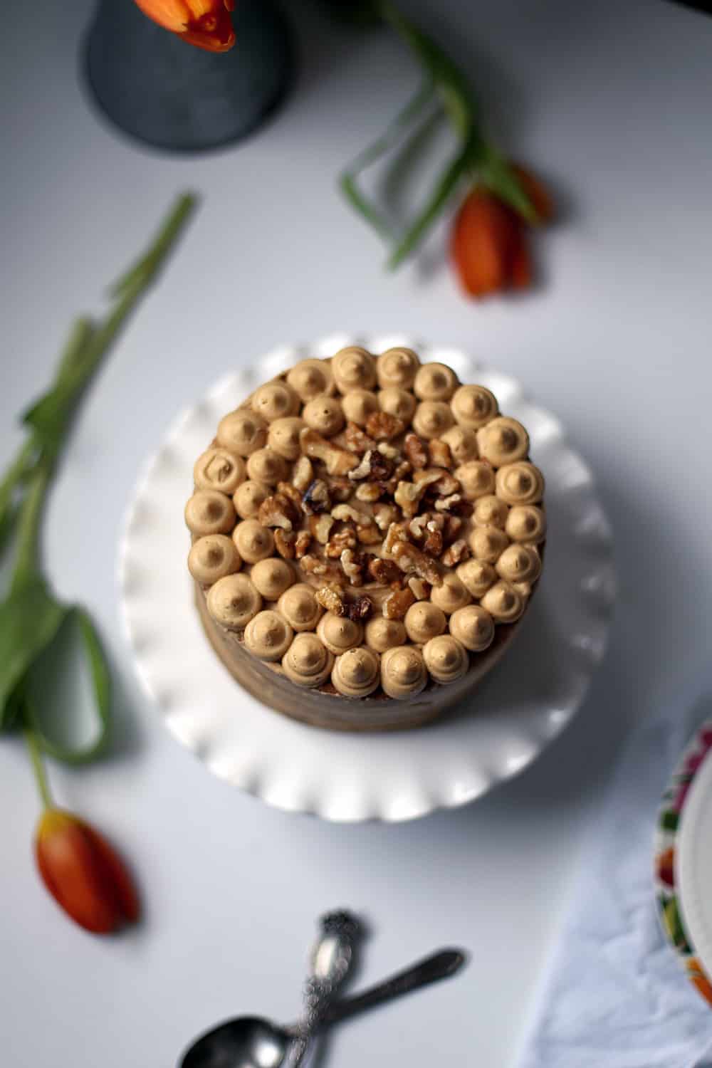 A coffee walnut cake frosted topped with walnuts. 