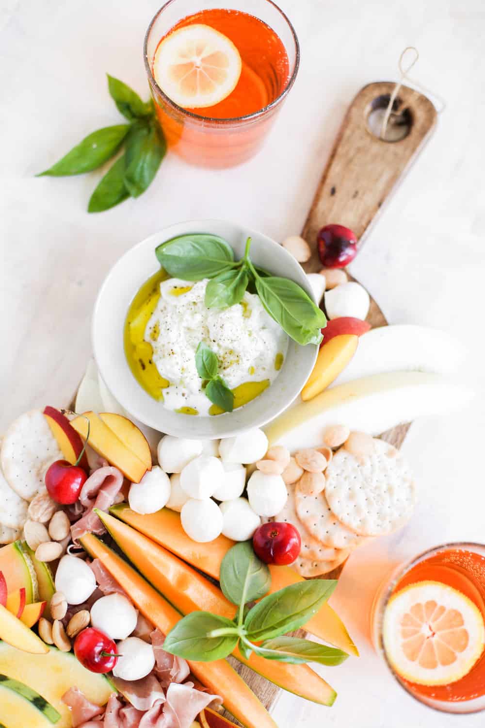 Italian Melon and Mozzarella Cheese Board with Drink and Burrata in white bowl