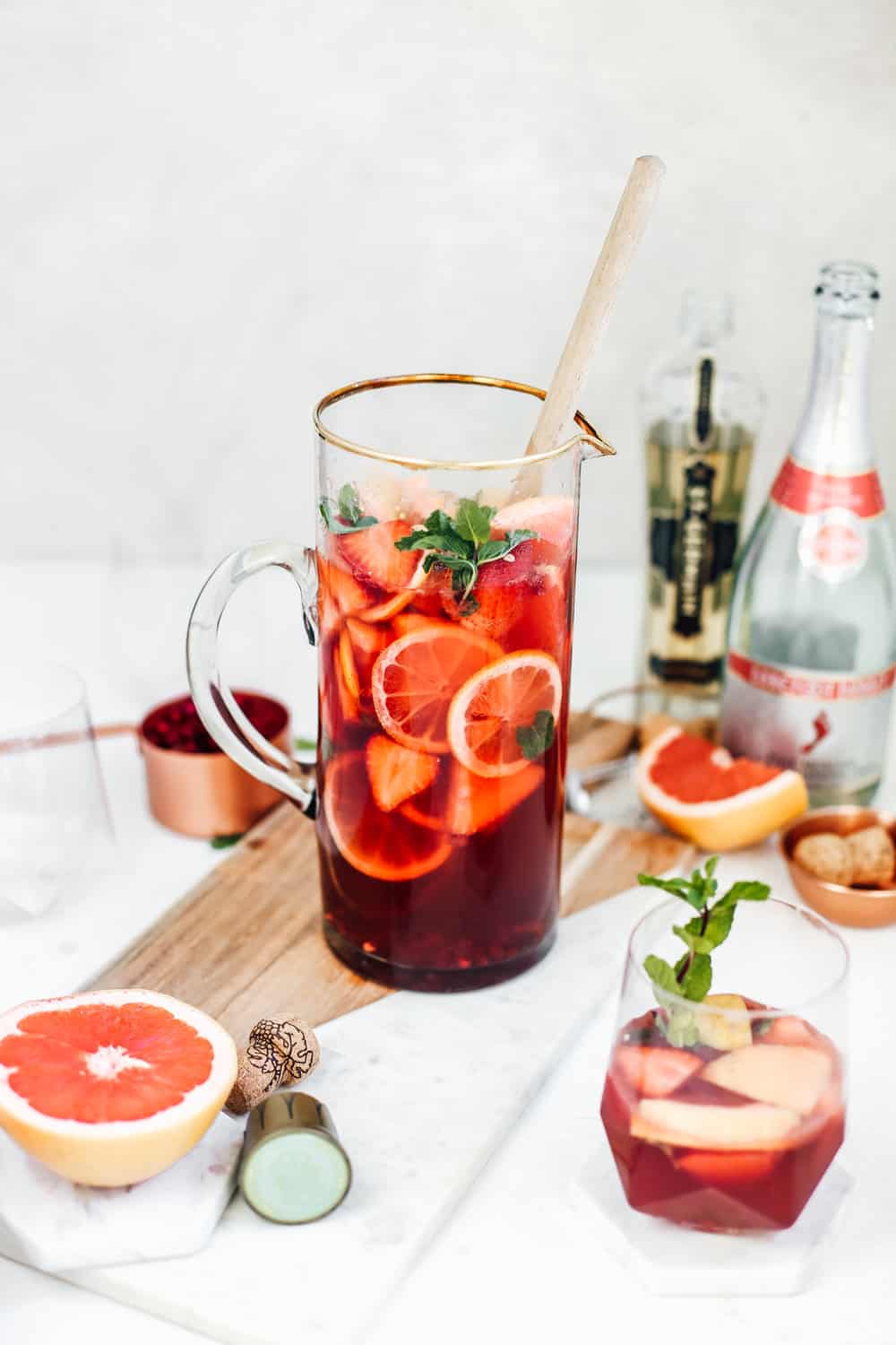 A glass pitcher of strawberry champagne sangria with fresh grapefruit and strawberry slices.