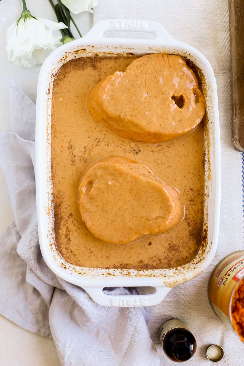 Flipped bread in pumpkin spice egg mixture in a casserole dish