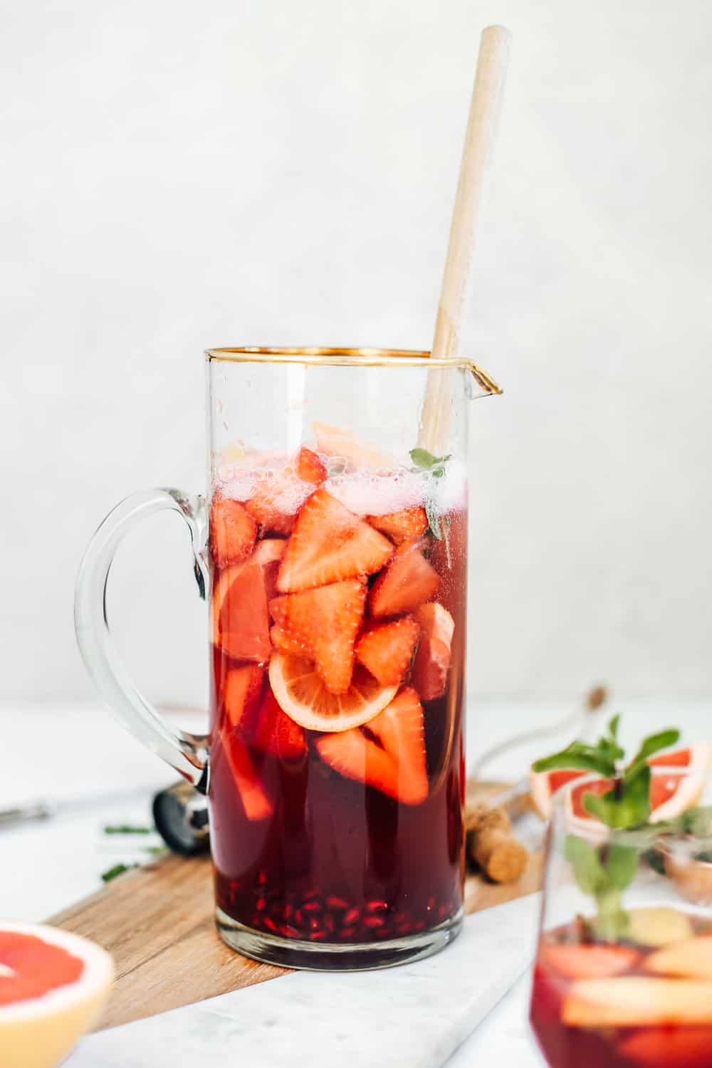 A pitcher of strawberry champagne sangria with fresh strawberry and grapefruit slices.