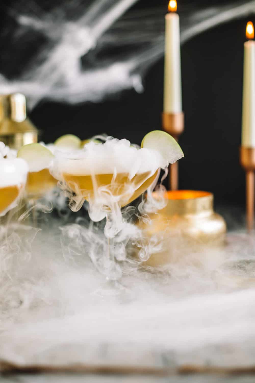 Elderflower Wand Martini garnished with dry ice and an apple slice. 