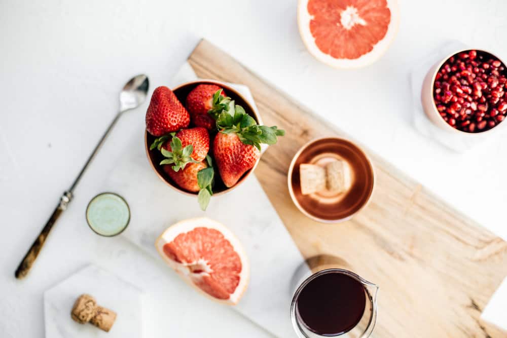 Fresh strawberries, grapefruit and pomegranate seeds for strawberry champagne sangria.