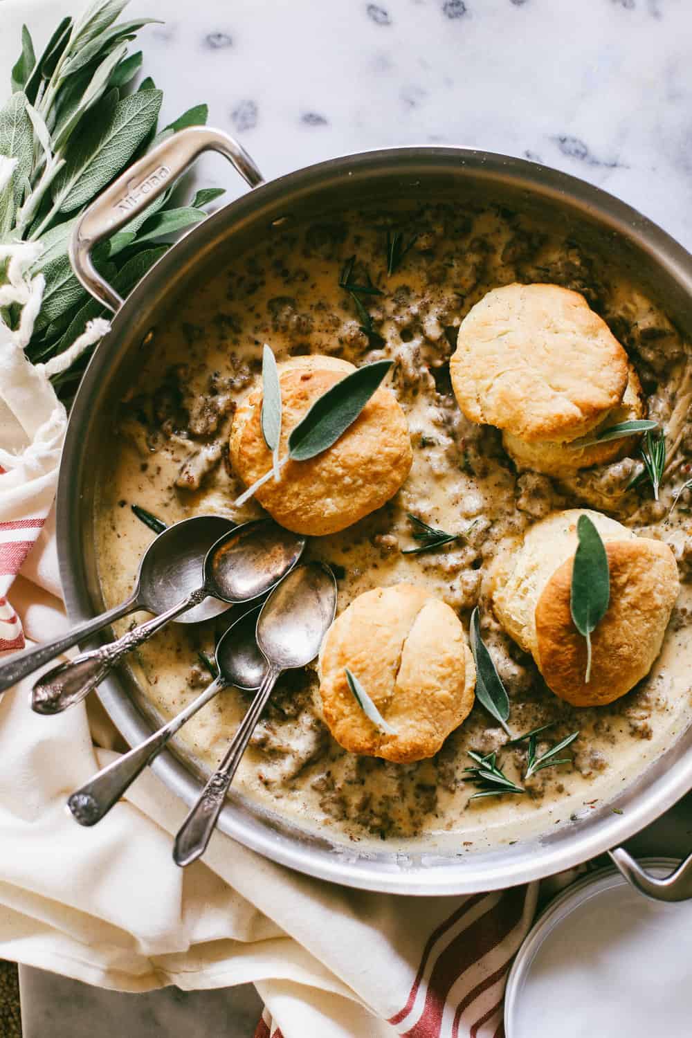 Bourbon Biscuits and Sage Sausage Gravy in a pan with spoons.