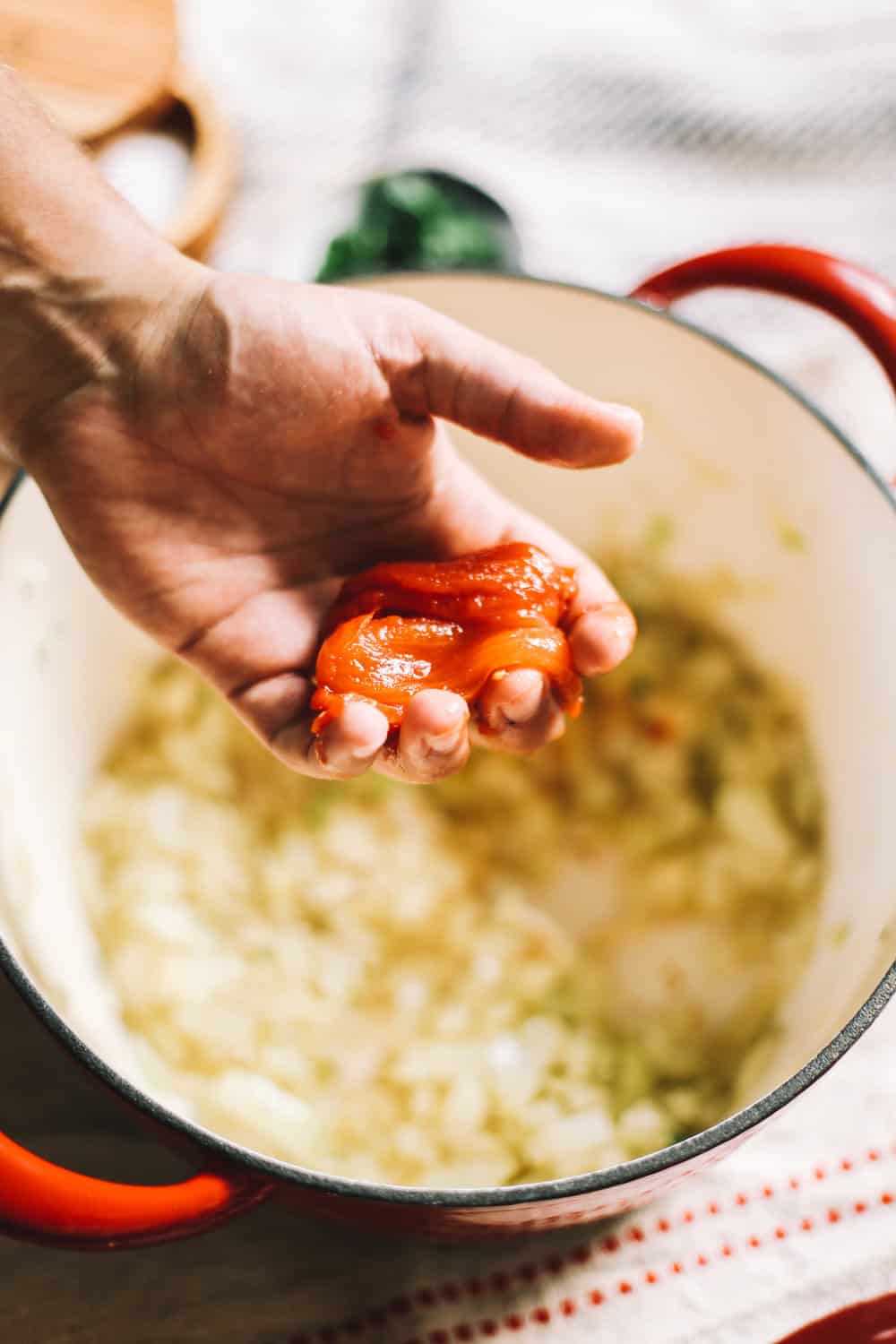 Adding tomatoes to homemade sauce. 