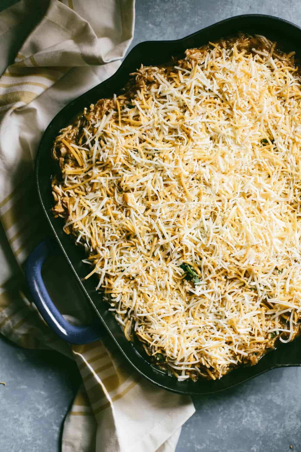 Green Chili Enchilada Cornbread Casserole pre baked with cheese on top. 