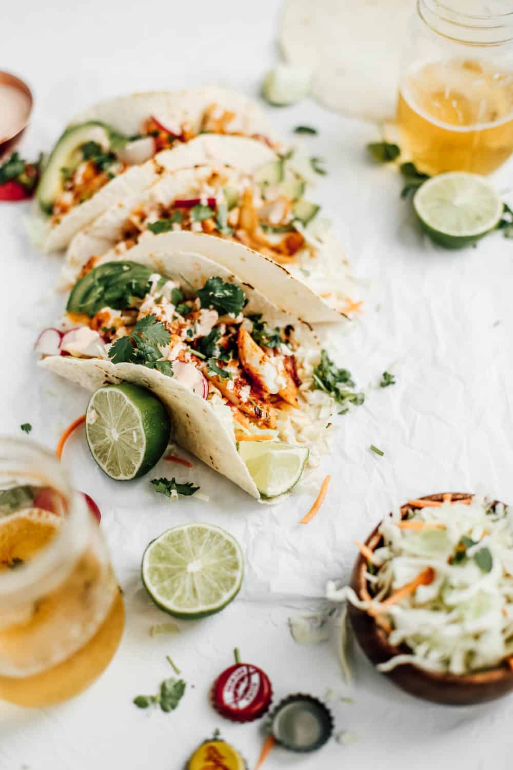 Blackened Cod Taco with a bowl of cabbage and a glass of beer.