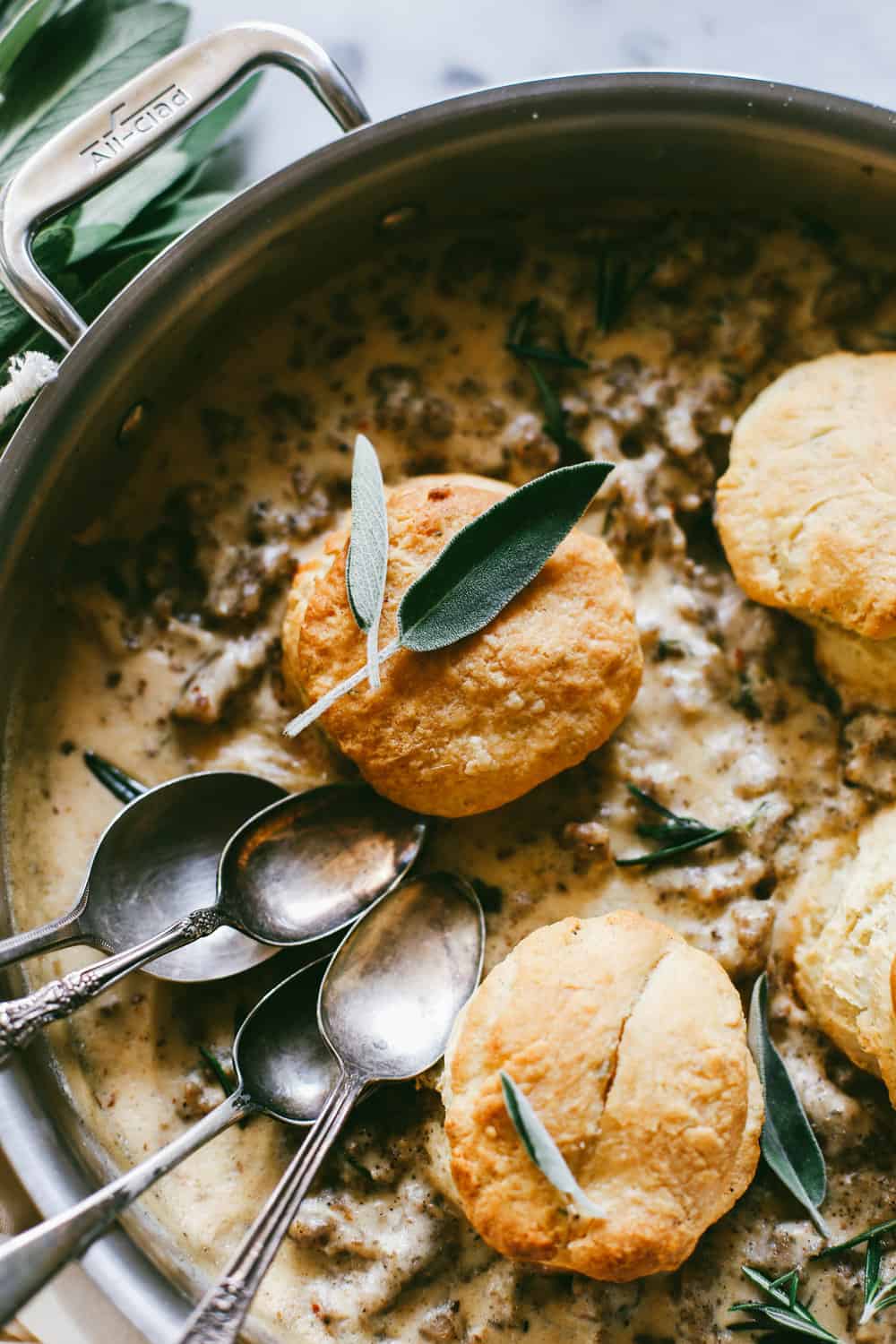 Bourbon Biscuits and Sage Sausage Gravy in a pan with spoons.