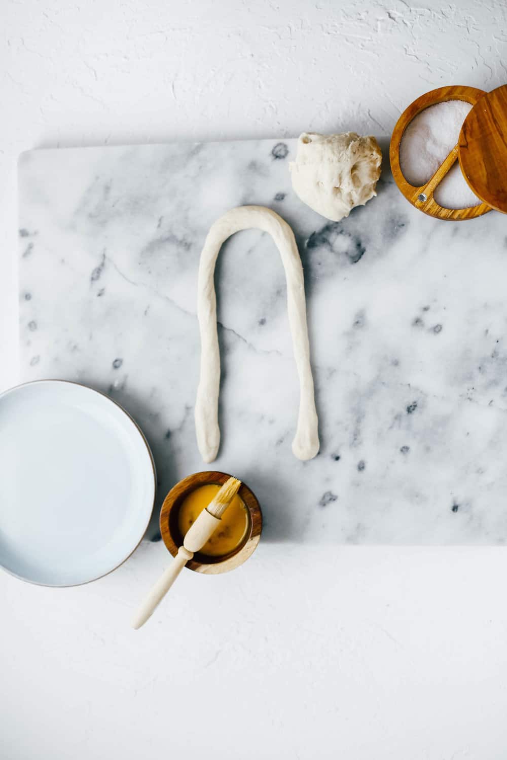 rolled pretzel dough on marble countertop