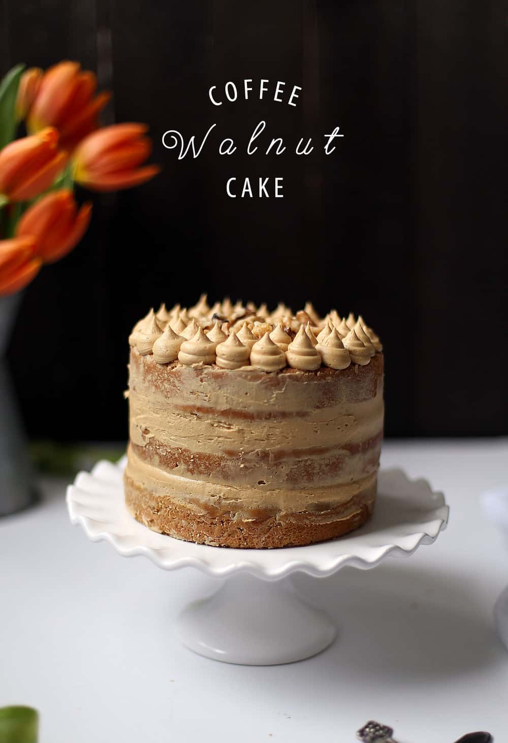 Three layer Coffee Walnut Cake on a white cake stand.