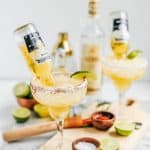 coronaritas with lime wedges and bowls of chili on the wooden board around them