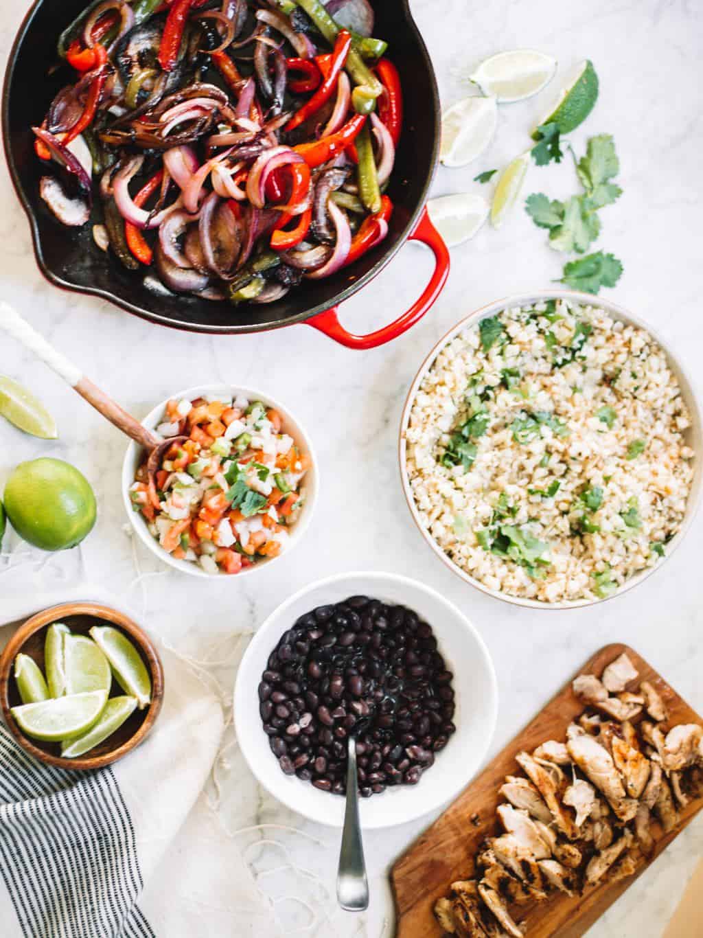 Chipotle style burrito bowls at home or for meal prep! These healthy bowls are made with cauliflower rice, juicy chicken, salsa and avocado crema!