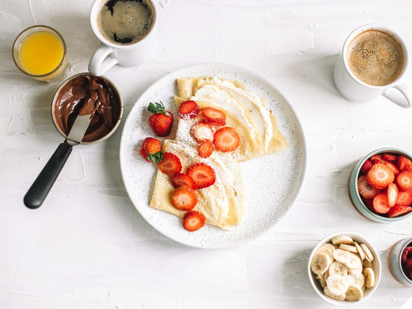 A plate of crepes with strawberries and sweet mascarpone filling