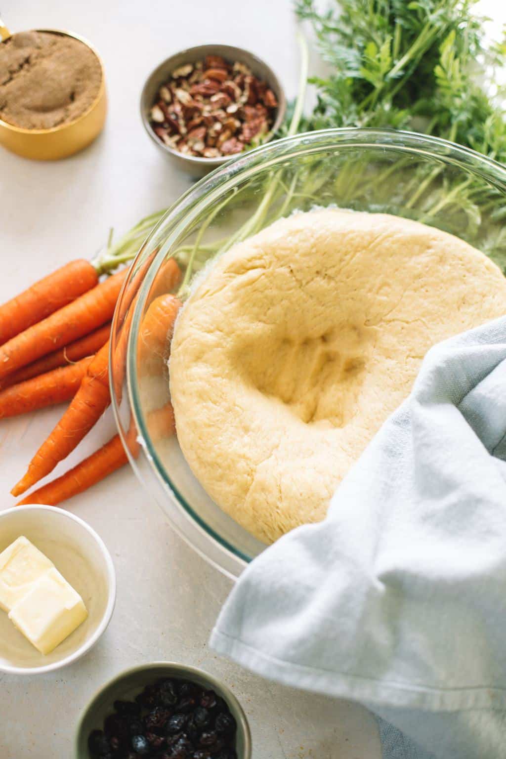 breakfast pastry dough in glass bowl with carrots and butter