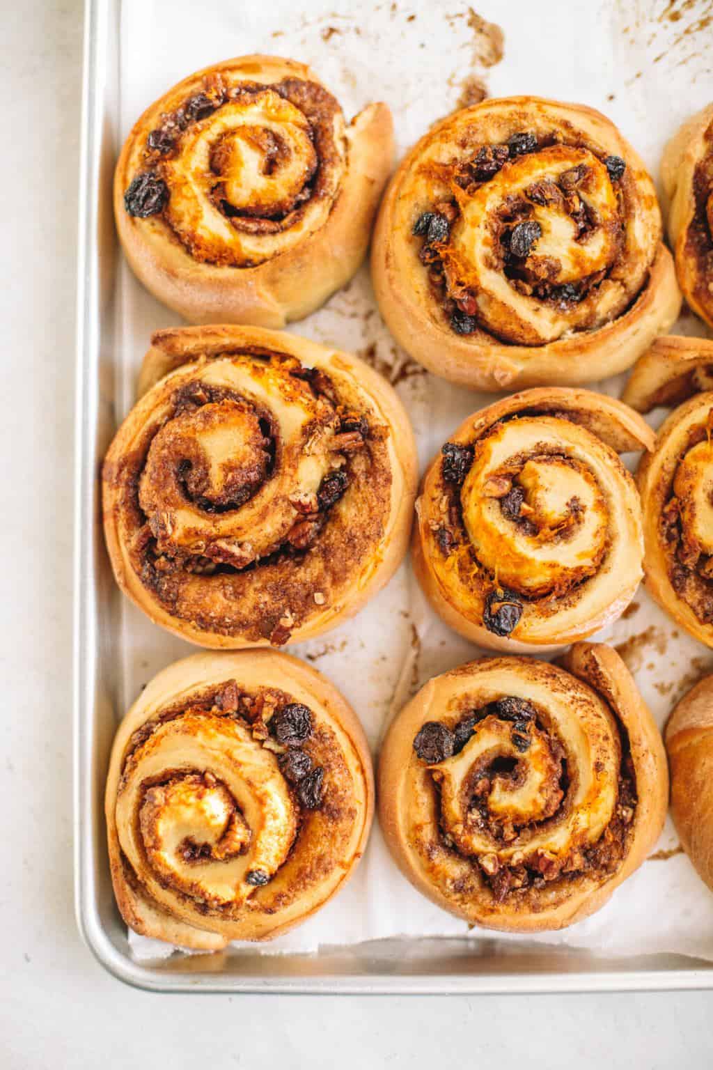plain cinnamon rolls with carrot cake filling on a baking sheet