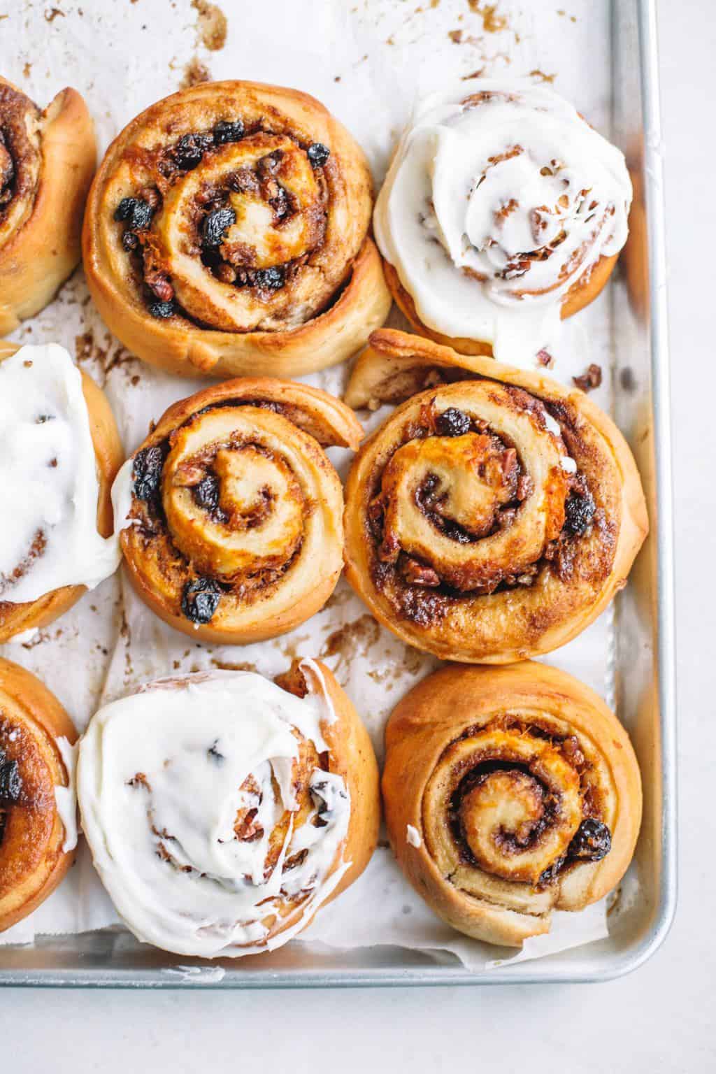 cream cheese glazed cinnamon buns on baking sheet