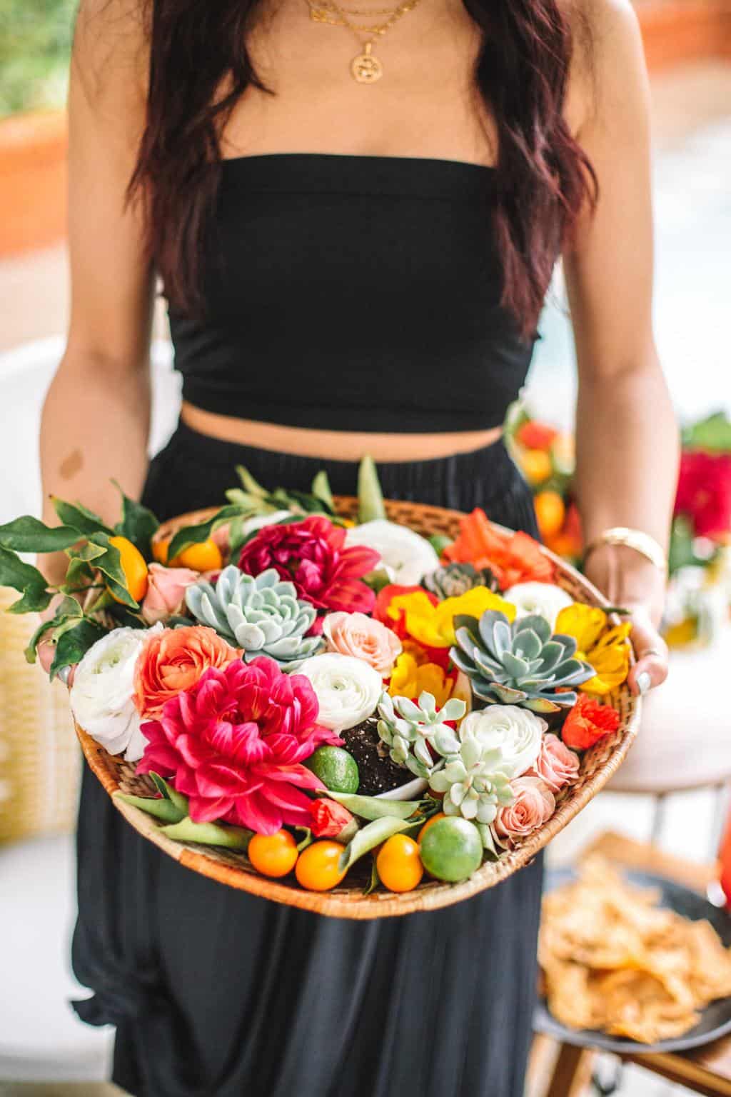 A girl holding a colorful flower arrangement. 