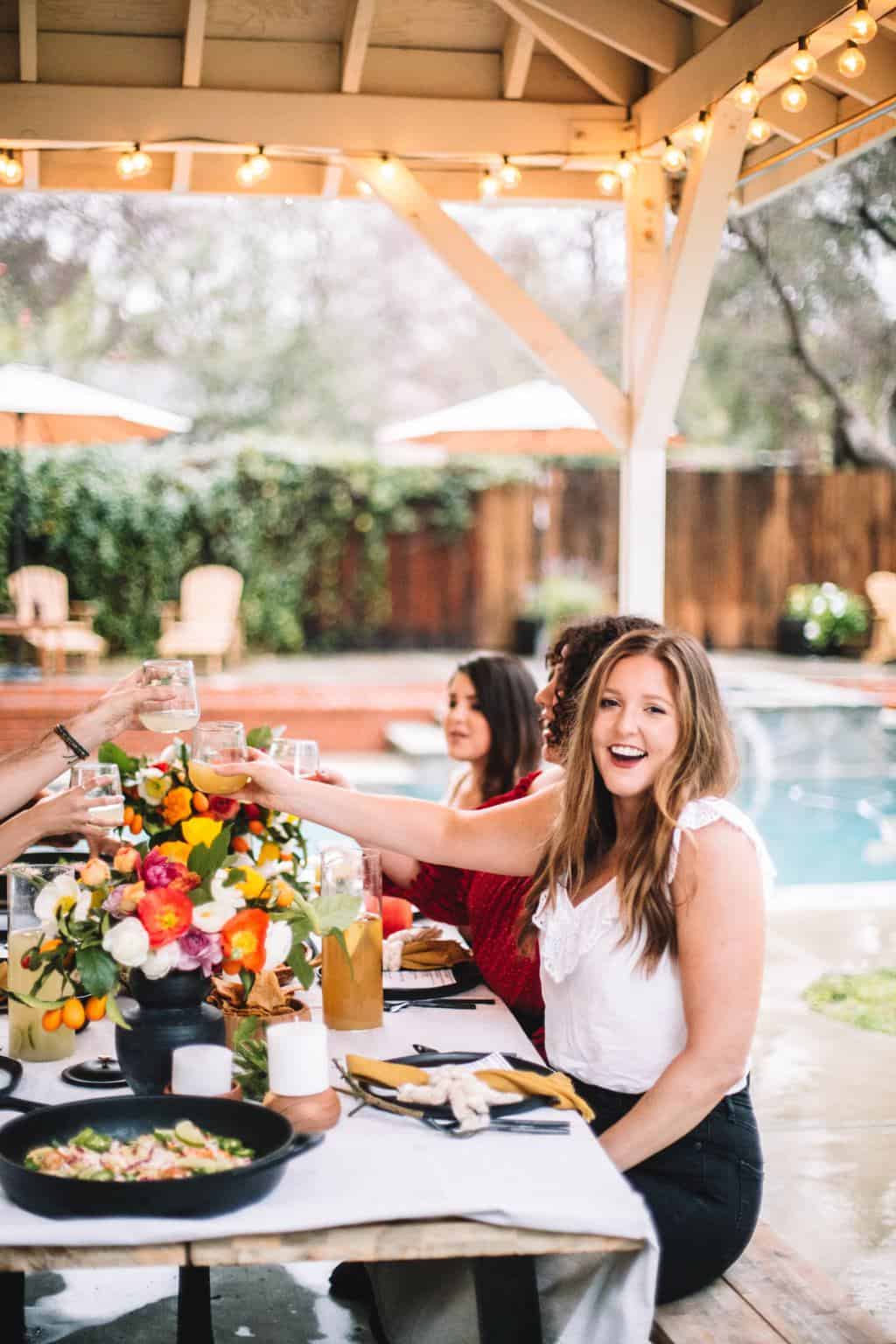 Friends at a dinner party outside in a backyard.