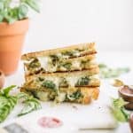 a stack of sliced grilled cheese with pesto