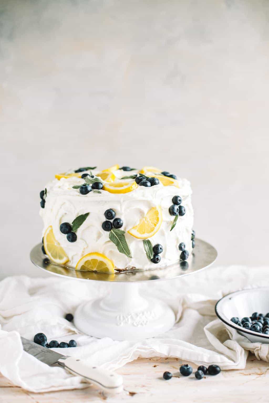 simple lemon blueberry cake with lemon buttercream on cake stand