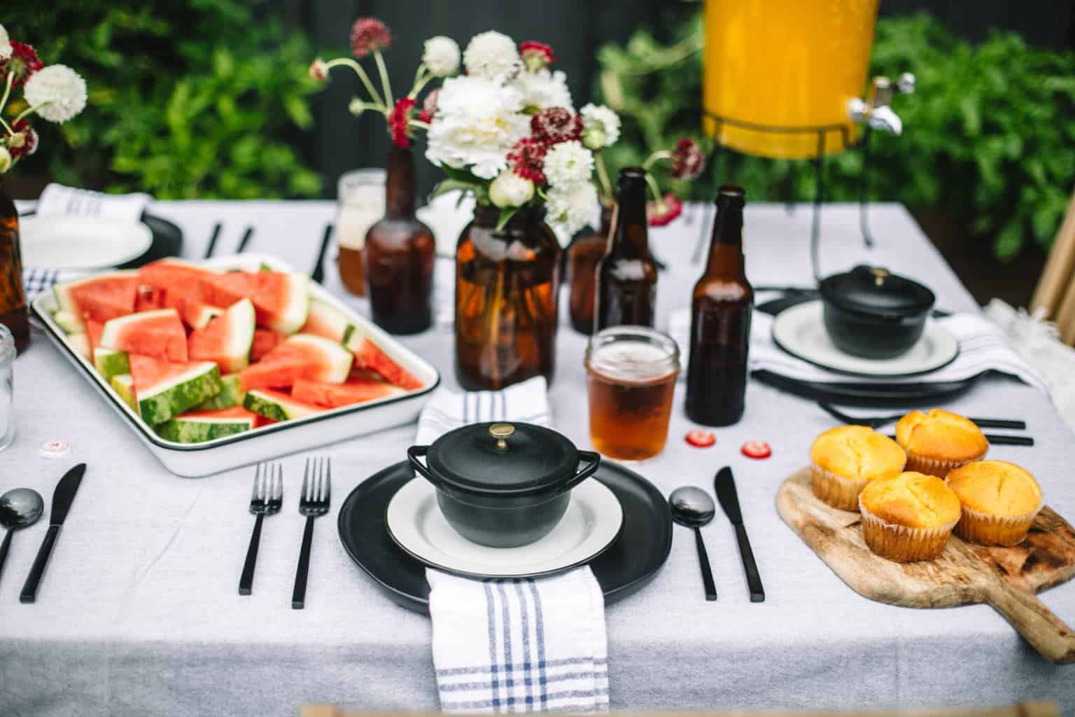 Fathers day table set up with a platter of watermelon, cornbread and beer bottles.