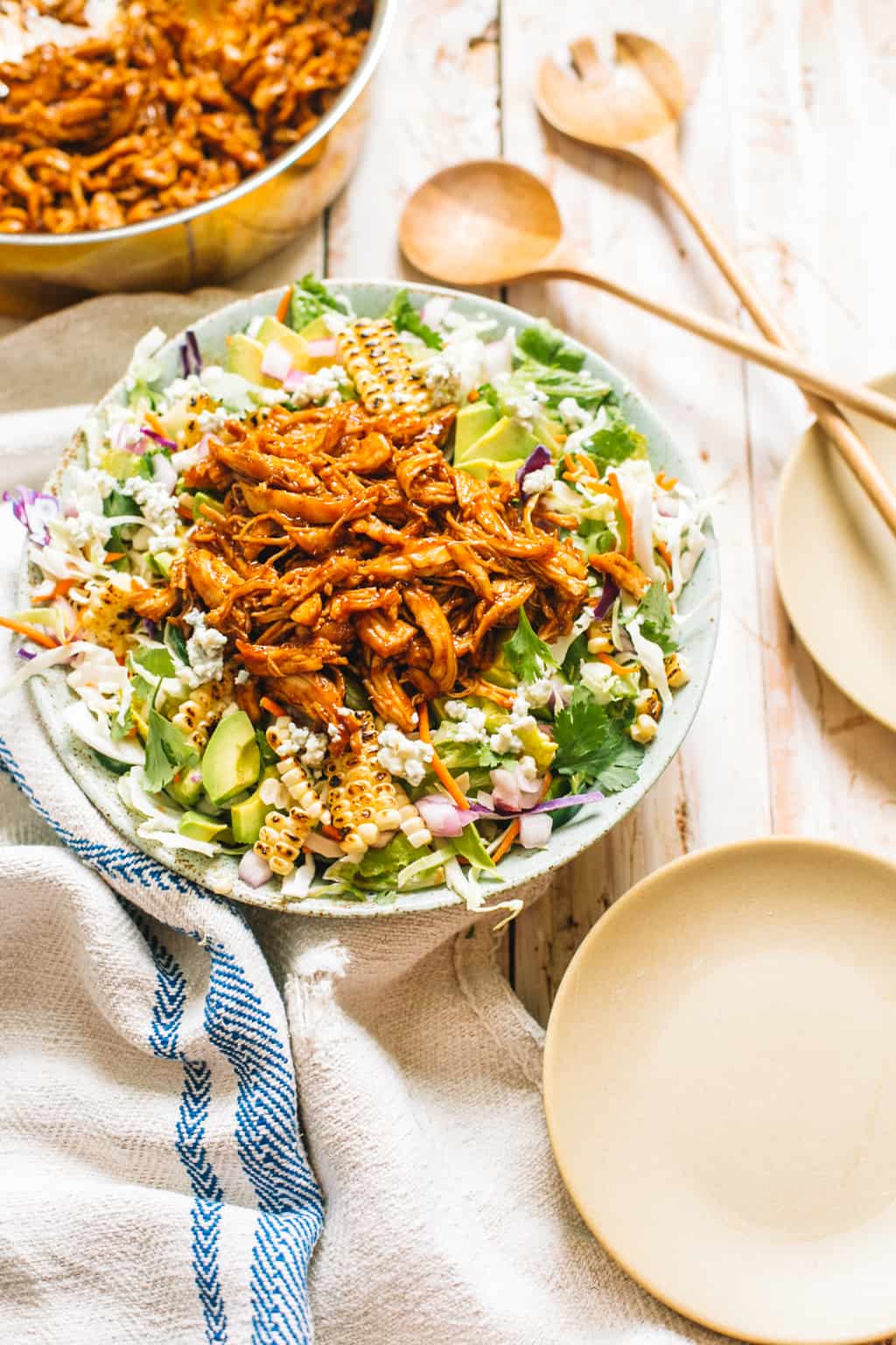 A bbq chicken salad made with coleslaw and shredded bbq chicken served in a blue serving bowl.