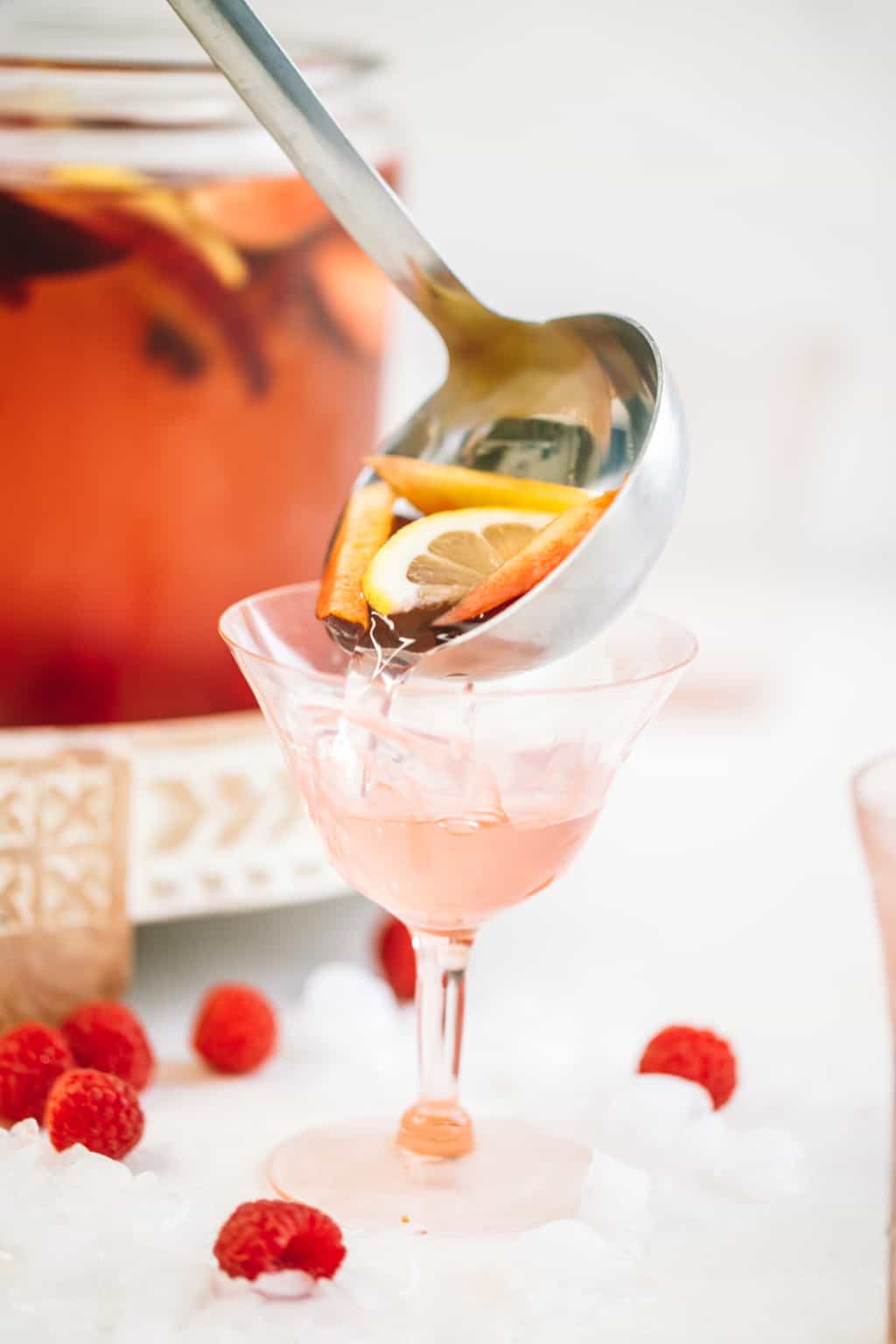 Ladle full of sangria being poured into a wine glass.